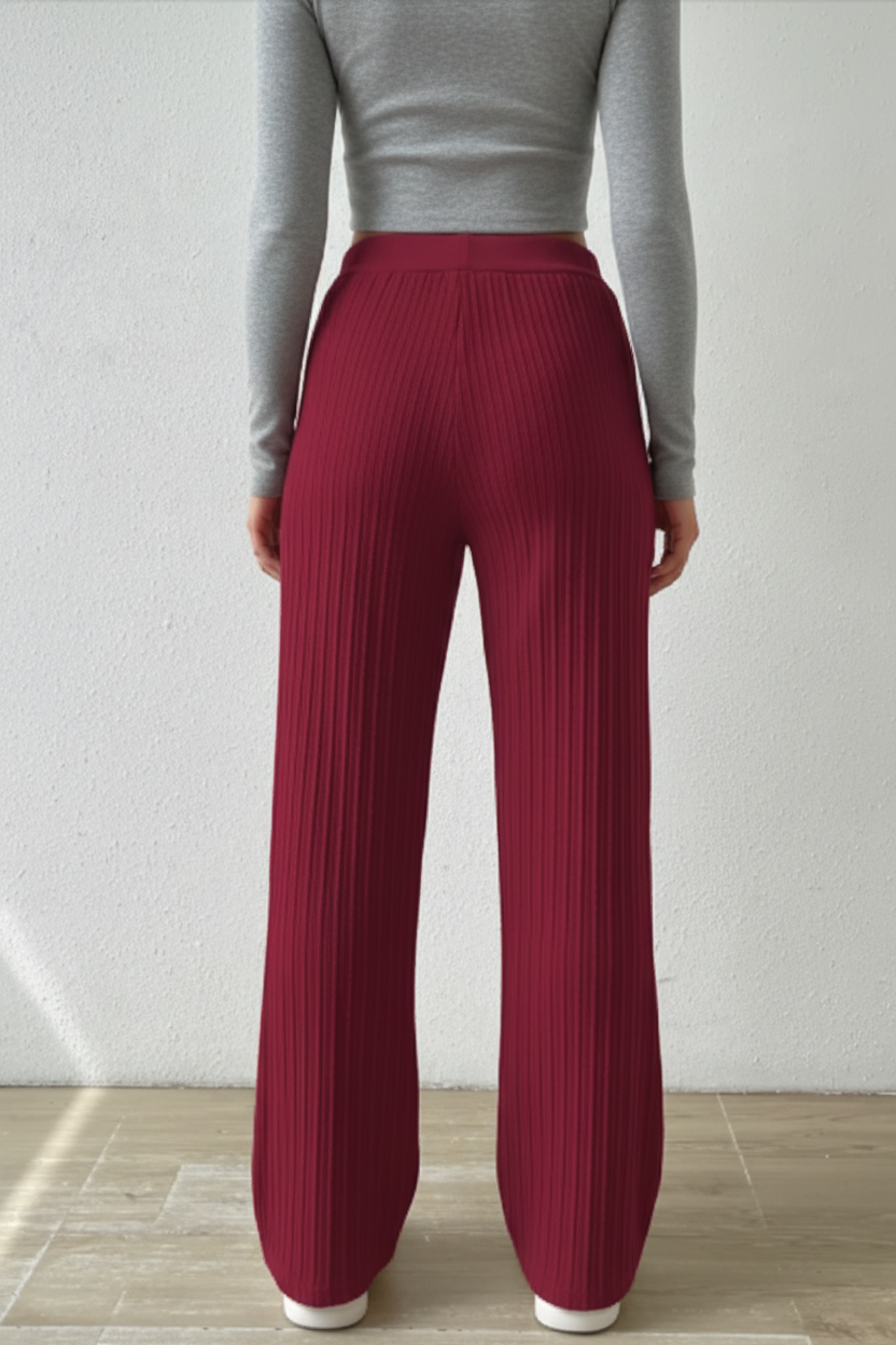 Back view of a person wearing wine-red sweater-knit wide-leg pants with a smooth waistband, standing in a candid indoor setting.